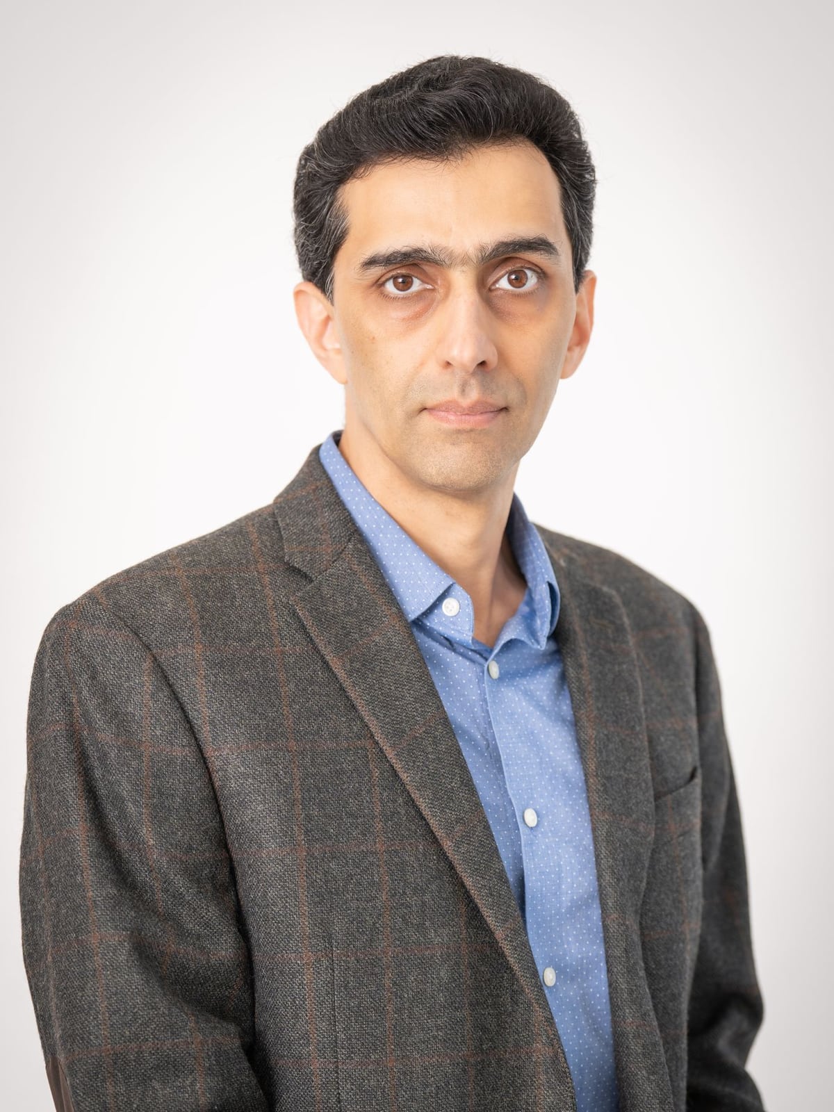 A professional corporate headshot of a businessman taken in a studio with classic lighting.