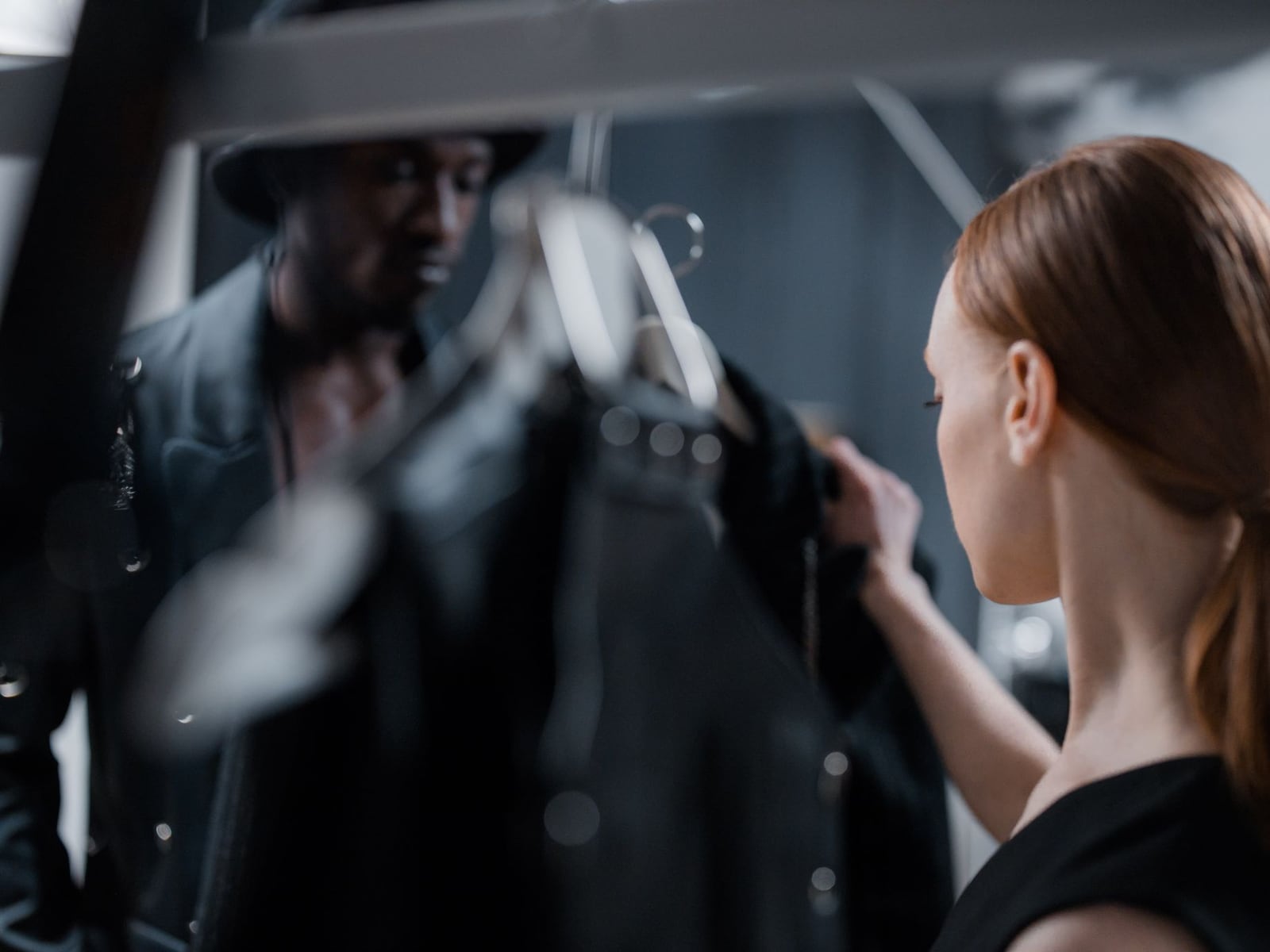 A selection of neutral-toned clothing on a rack, illustrating preparation for a portrait session.