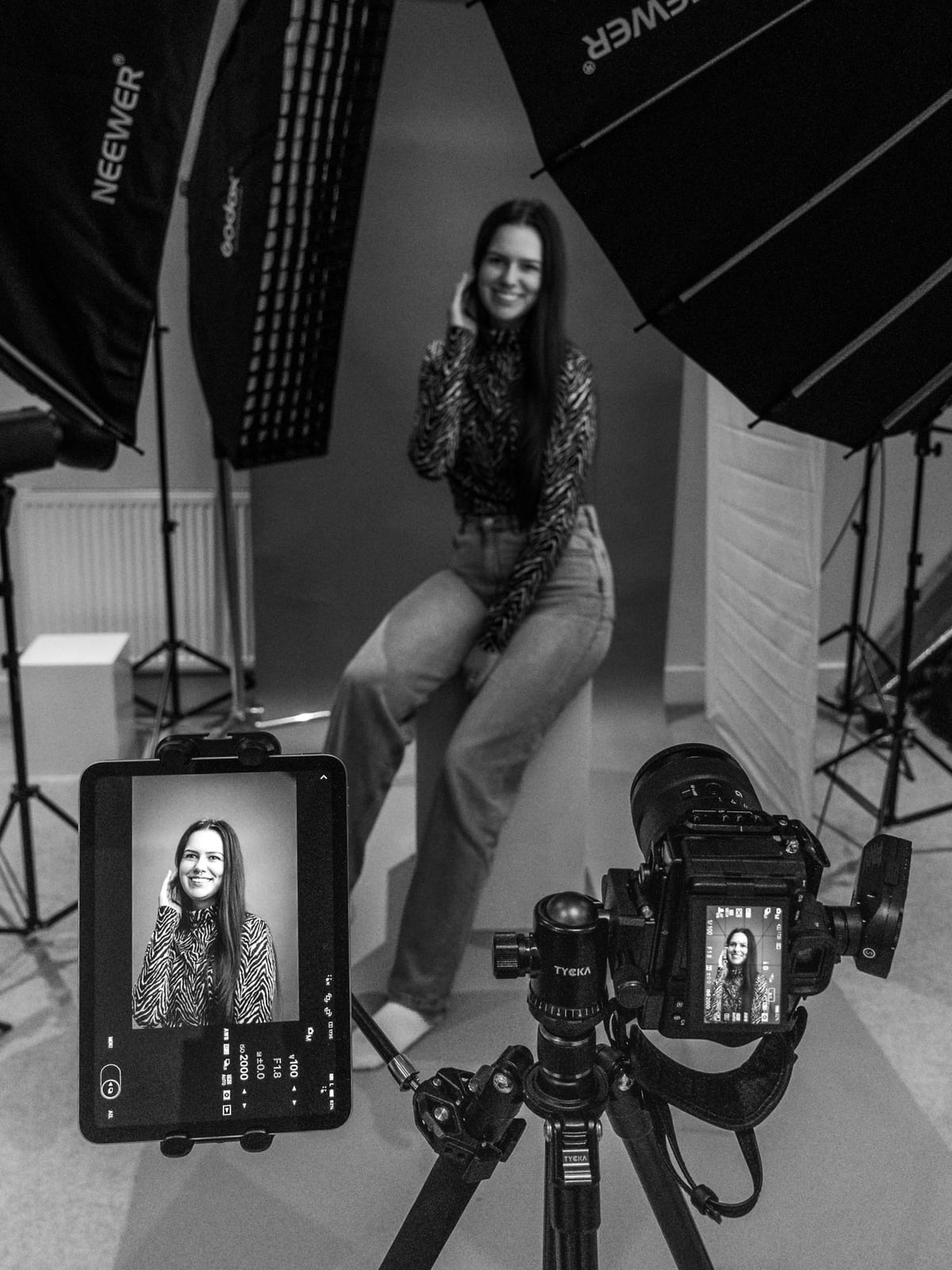 A professional portrait session in progress with a model and photographer in a controlled studio environment.